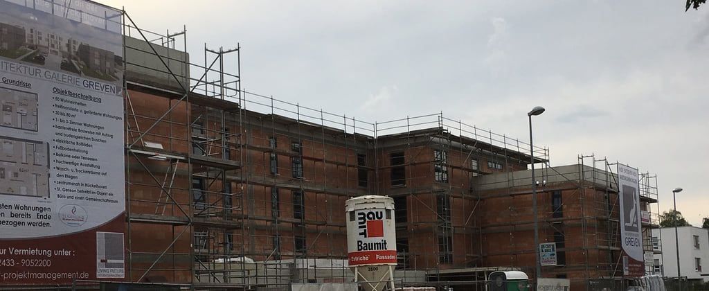 Panoramaausschnitt der eingerüsteten Ziegelfassade, die Gerüstlagen laufen über die gesamte Gebäudelänge